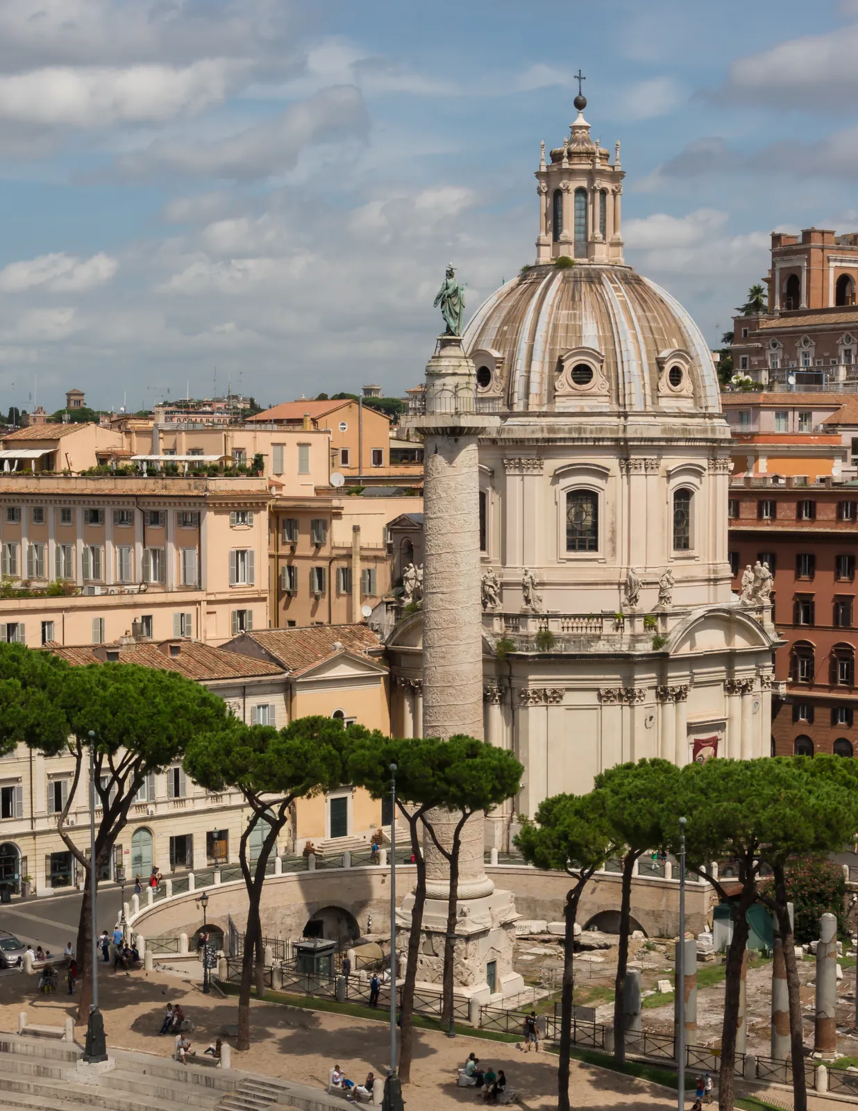 Trajan's Column standing in the Forum of Trajan, Rome — the spiral narrative relief of the Dacian Wars rising the full height of the shaft, with the dome of Santissimo Nome di Maria behind.