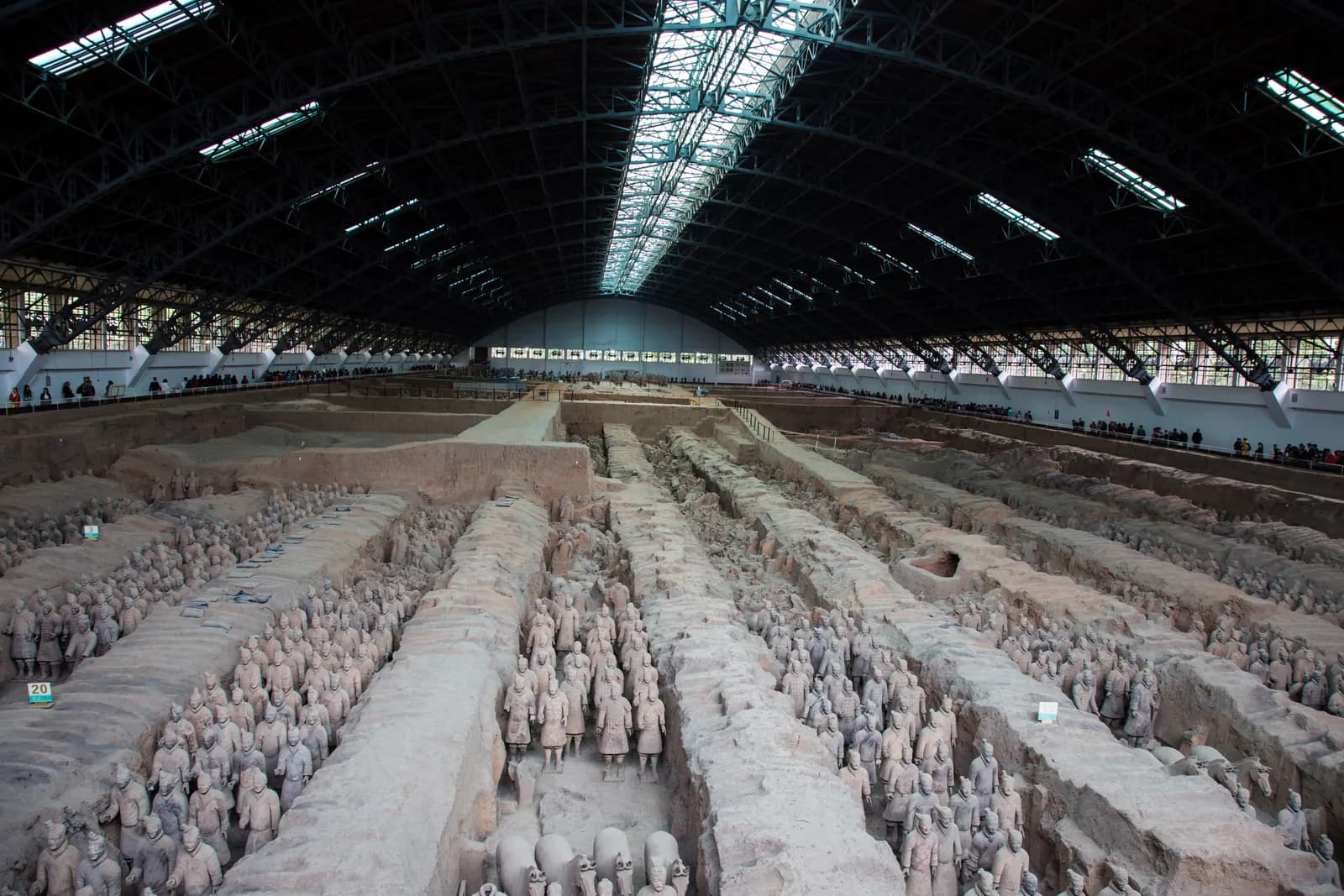 Ranks of life-size terracotta soldiers standing in the excavated earthen corridors of Pit 1 at the mausoleum of the First Emperor of China, the army drawn up in formation underground.
